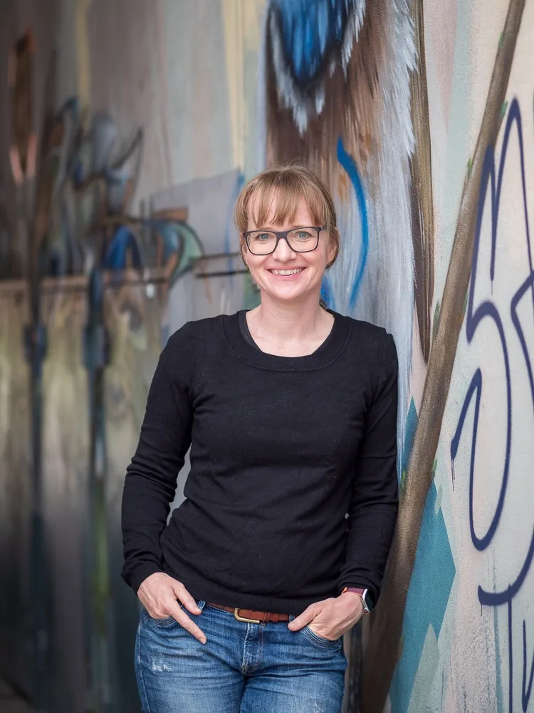 Kerstin Schoch vor einer mit Graffiti bemalten Wand